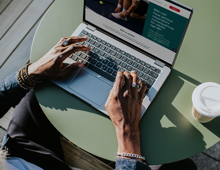 Person viewing ABRYSVO® information online about RSV prevention in older adults.